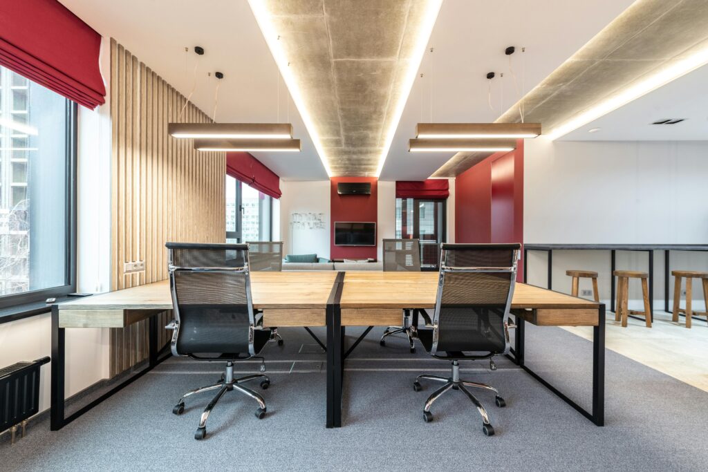 Spacious contemporary office with wooden desks and ergonomic chairs.